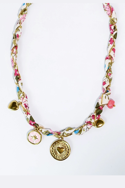 Floral patterned necklace with heart-shaped charms on a white background