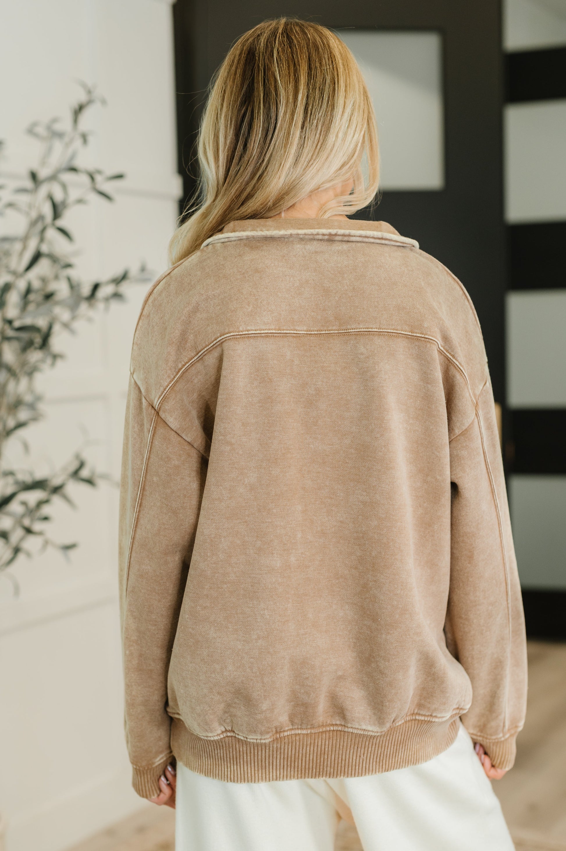 Person wearing a beige jacket in an indoor setting