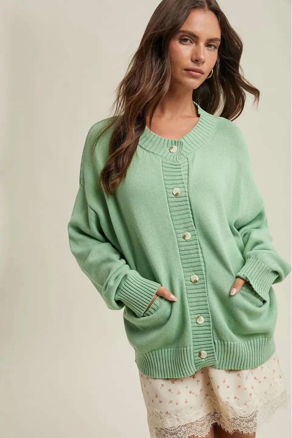 Woman wearing a green cardigan against a neutral background