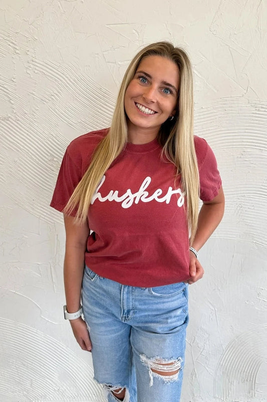 White Sparkle Cursive Huskers - Crimson Tee