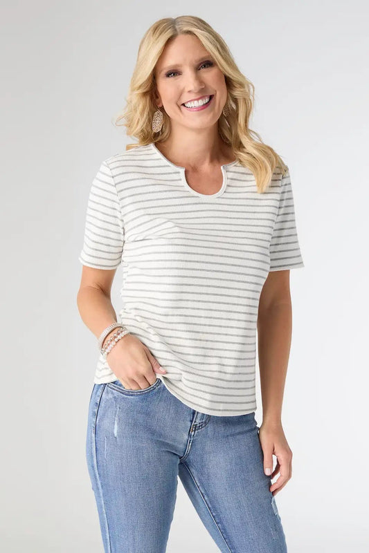 Woman wearing a striped shirt and jeans on a plain background