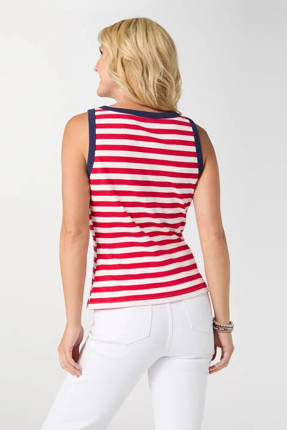 Woman wearing a red and white striped sleeveless top with navy trim on a plain background