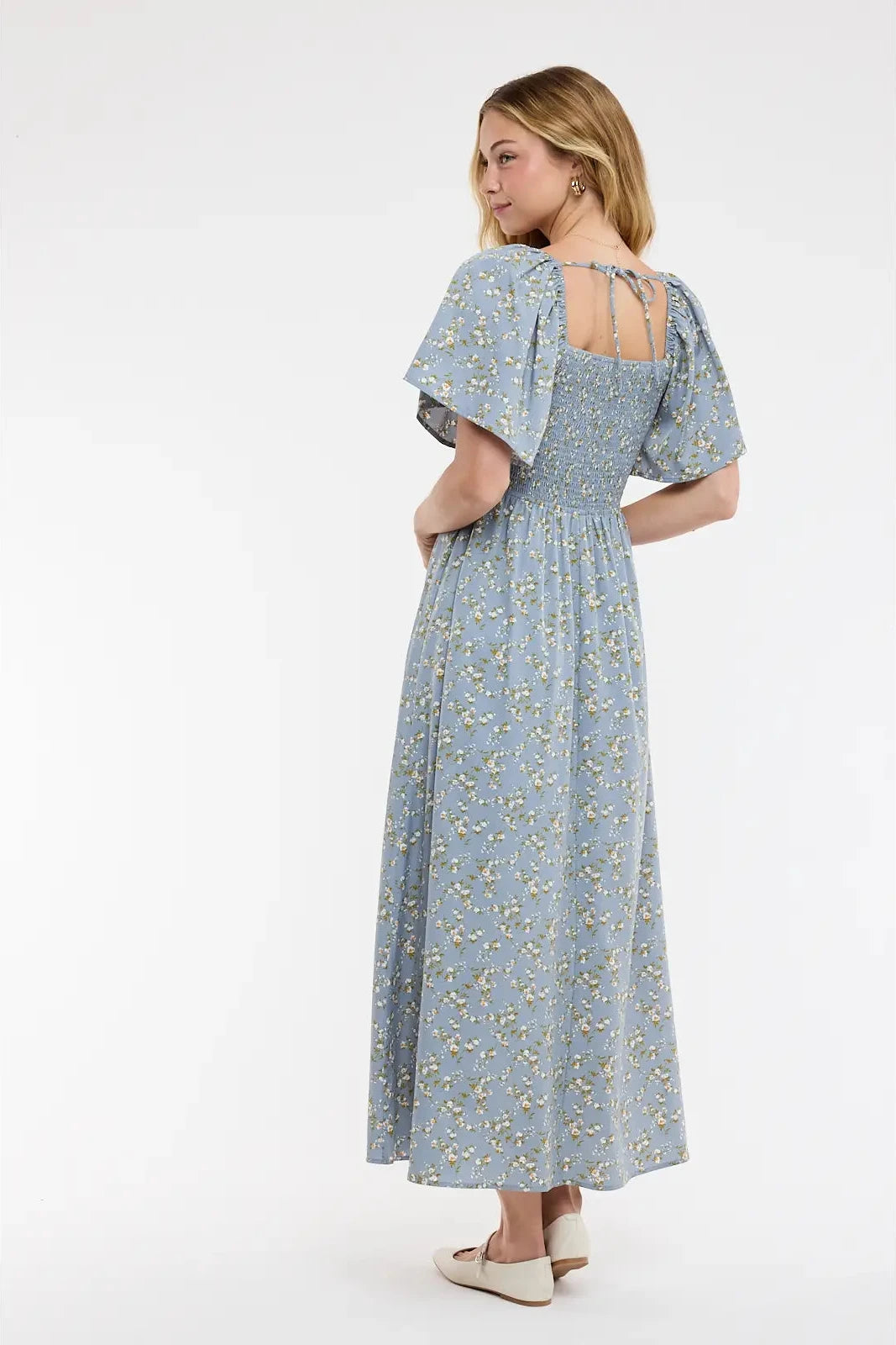 Woman wearing a blue floral dress on a white background