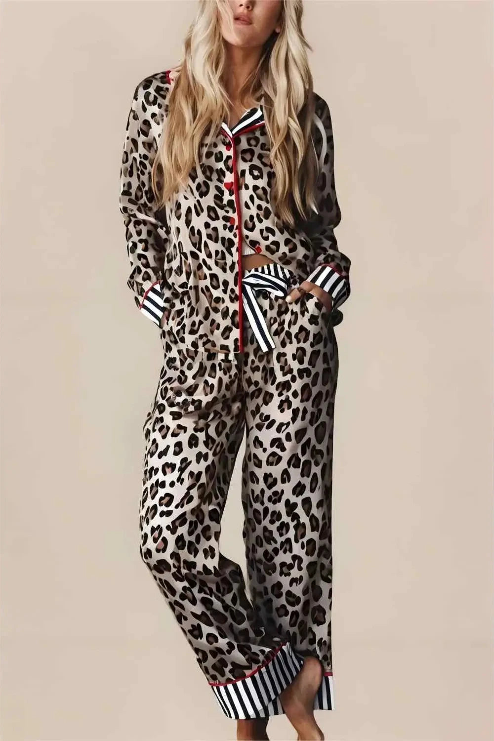 Woman wearing a leopard print pajama set with striped cuffs on a beige background