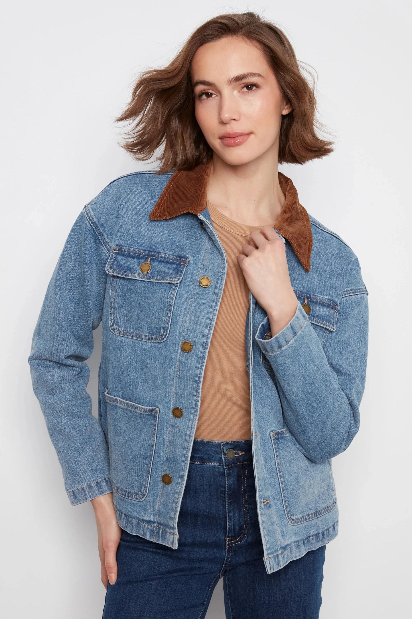 Woman wearing a blue denim jacket with brown collar on a white background