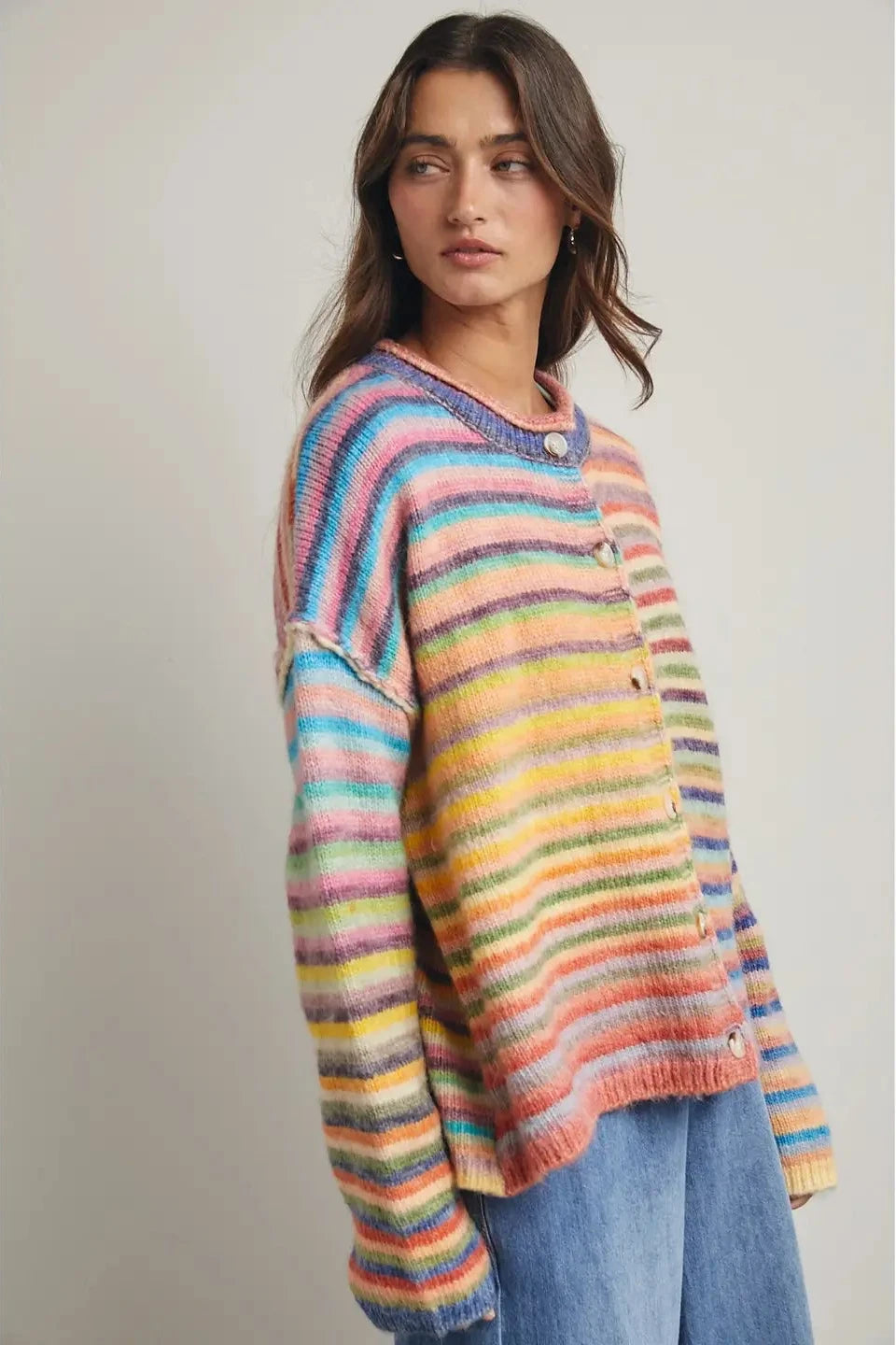 Woman wearing a colorful striped sweater against a plain background