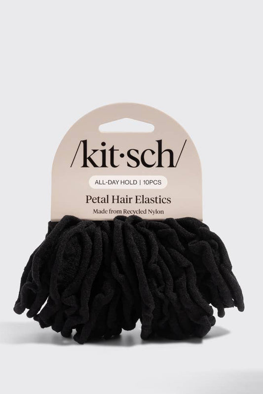 A pack of black ruffled petal hair elastics shown next to their beige paper header card. The brand name 'kit-sch' is clearly printed on the packaging.