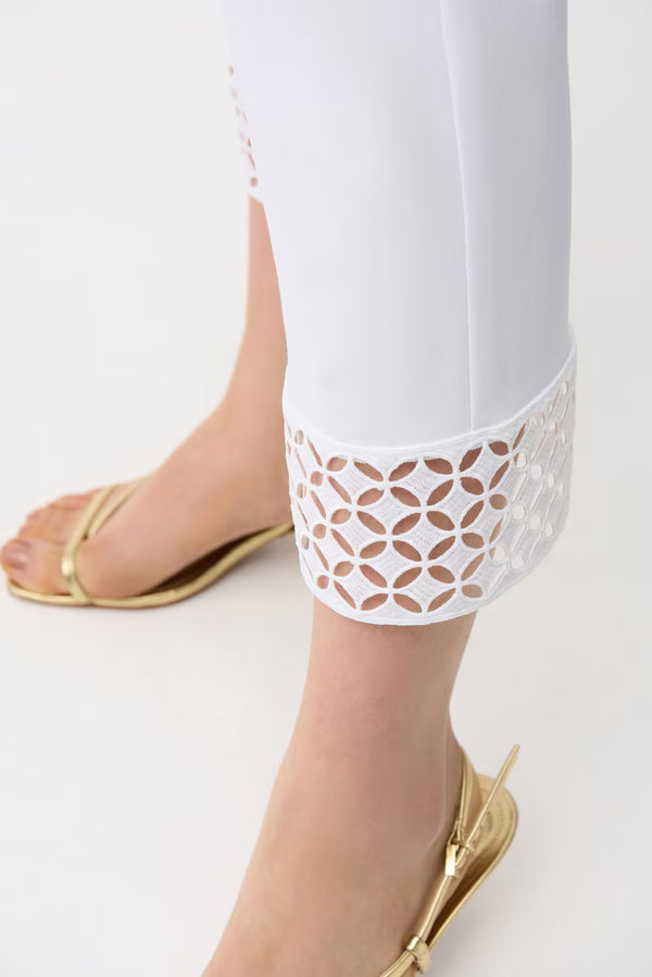 White pants with lace trim worn by a person on a white background
