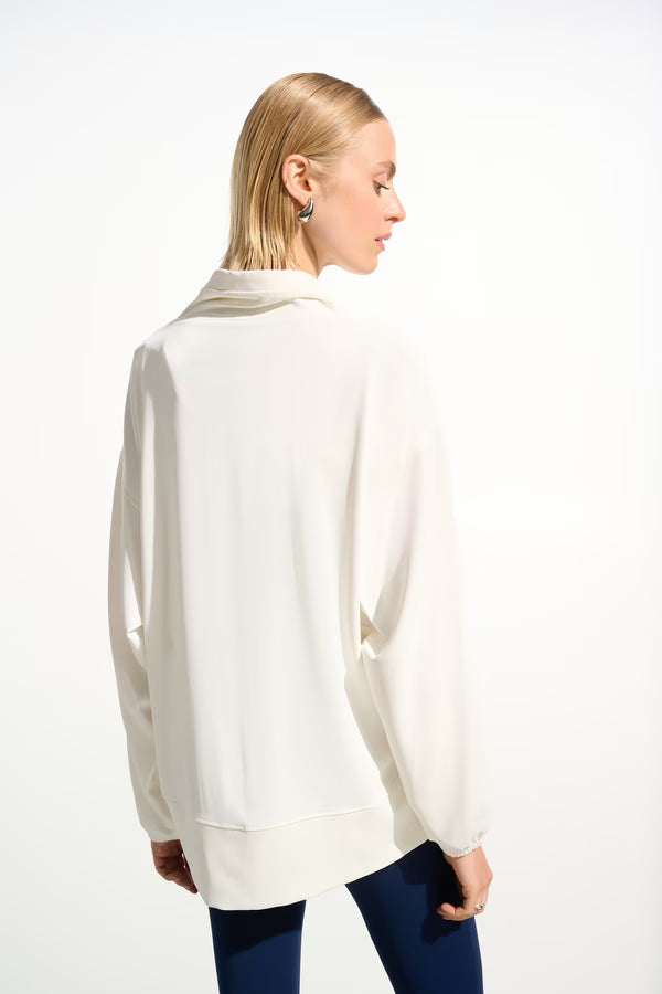 Woman wearing a white long-sleeve top on a white background