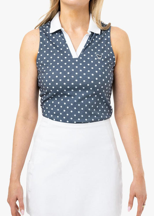 Woman wearing a sleeveless polka dot top and white skirt on a white background